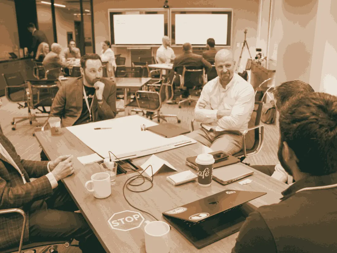 Lending executives working through a build at four tables